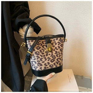 Close-up of leopard print bucket bag featuring black leather trim and gold metal lock