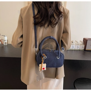 Détail du sac à main bleu marine dépoli avec charm ours en peluche et boucle en métal