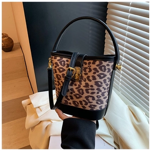 Detailed view of leopard print bucket bag with black leather trim and gold metal buckle