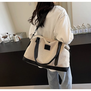 Vue détaillée du sac fourre-tout en toile beige avec garniture en cuir noir et bandoulière