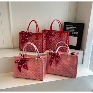 Detail of red and pink bridal tote bags featuring traditional double joy jacquard pattern