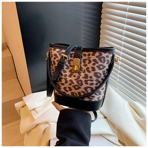 Close-up of leopard print bucket bag featuring a golden metal twist lock and black leather trim