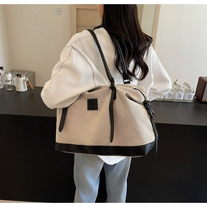 Vue détaillée d'un grand sac cabas en toile beige avec finitions et anses en cuir noir