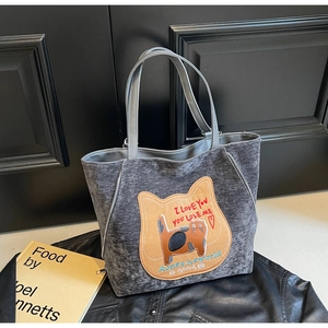 Dettaglio della borsa tote in pelle scamosciata grigia con ricamo di gatto e manici