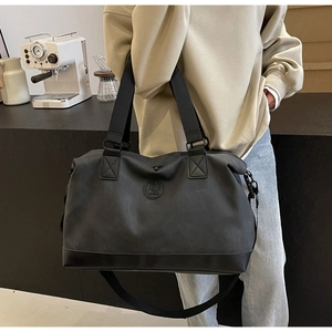 Detailed view of the large black travel bag with adjustable strap in a modern setting