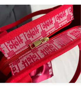 Detail of a red bridal canvas tote featuring high-quality gold zipper and intricate embroidery