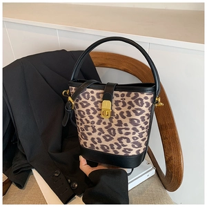 Detailed view of leopard print bucket bag with black leather trim and gold twist lock
