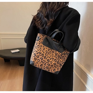 Leopard print bucket bag with black leather trim shown on model for size perspective