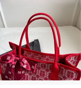 Detail of red wedding tote bag with woven handles and silk double happiness bow