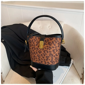 Detail of leopard print bucket bag with gold twist lock on a white chair
