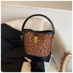 Macro detail of leopard print bucket bag featuring gold buckle and black leather strap