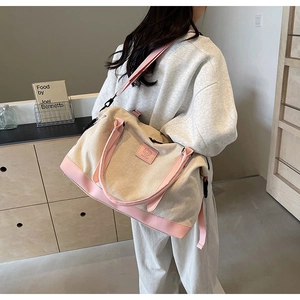 Détail du sac de voyage en toile avec bordure en cuir rose et bandoulière réglable