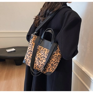 Detail shot of leopard print tote bag with black leather trim and wide shoulder strap