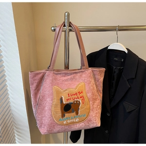 Dettaglio della borsa tote in ciniglia rosa con ricamo a gatto e manici in pelle
