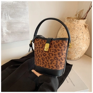 Close-up of leopard print bucket bag with black leather trim and gold metal twist lock