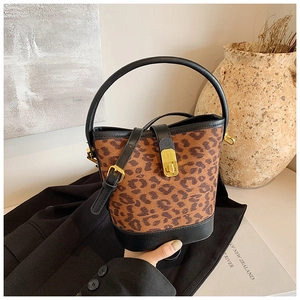 Detail view of leopard print bucket bag with gold hardware and black leather trim