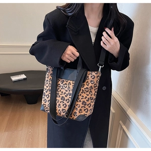 Leopard print tote bag with black leather reinforced corners and crossbody strap details