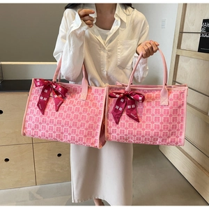 Detail of pink bridal tote bag featuring double bow ribbons and festive Xi character pattern
