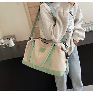 Détail du sac de voyage en toile beige et vert avec bandoulière réglable pratique