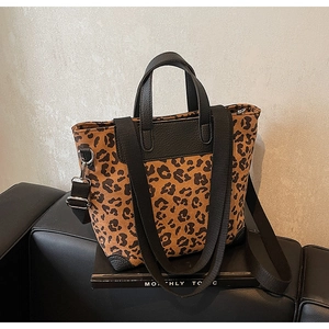 Close-up of leopard print tote bag with black leather handles and silver hardware