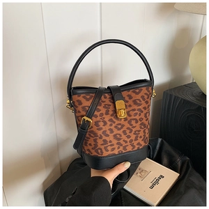 Detail of vintage leopard print bucket bag featuring a gold twist-lock and leather trim