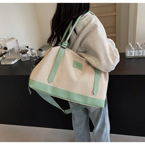 Grand sac cabas en toile avec bandoulière vert menthe et logo en cuir dans un café
