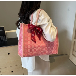 Detail of pink bridal tote bag with red Xi characters and a large silk bow decoration