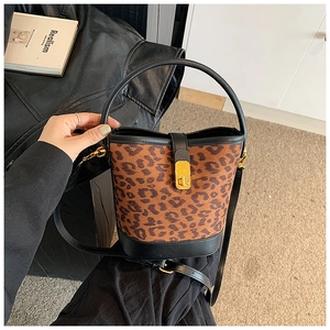 Detail of leopard print bucket bag featuring gold turn-lock and black leather handle