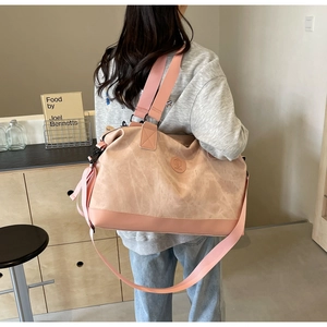 Pink large-capacity travel bag shown on a model in a natural lifestyle setting