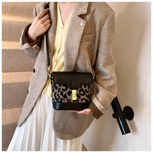 Detailed view of leopard print bucket bag with gold clasp shown on a model