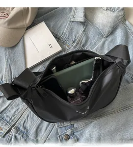 Intérieur spacieux du sac croissant noir contenant des cosmétiques et objets du quotidien