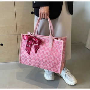 Detail of pink jacquard tote bag with Xi character patterns and red satin bow