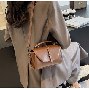 Brown vintage square handbag shown with adjustable strap in a stylish lifestyle setting