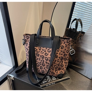 Close-up of leopard print tote with black leather trim and detachable shoulder strap