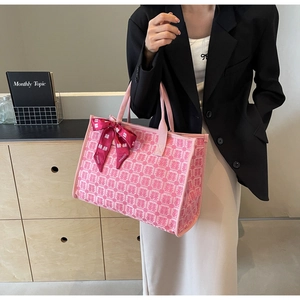 Detailed close-up of pink jacquard tote bag with Xi character patterns and red silk ribbon