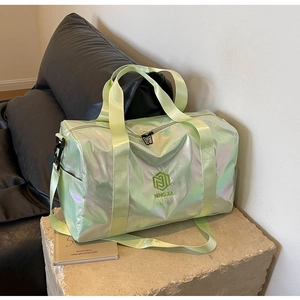 Close-up of holographic travel bag showing iridescent green fabric and logo embroidery