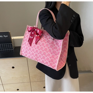 Detailed pink tote bag featuring traditional wedding patterns and a red bow ribbon