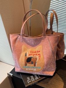 Borsa tote rosa viola con ricamo a gatto e manici in pelle marrone in un display a specchio