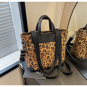 Detail view of leopard print tote bag with leather handles and wide nylon shoulder strap