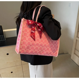 Detailed texture of pink festive tote bag with red Xi characters and satin ribbon bow