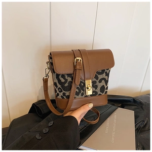 Detailed close-up of retro leopard print crossbody bag with vintage golden metal twist lock