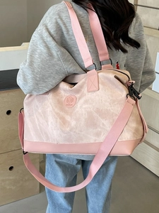 Pink large capacity travel duffel bag with shoulder strap shown on a female model