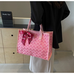 Detail of pink wedding tote bag with red Xi characters and decorative bow scarf