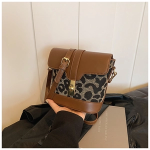 Detail of vintage leopard print crossbody bag with metal twist lock and leather trim