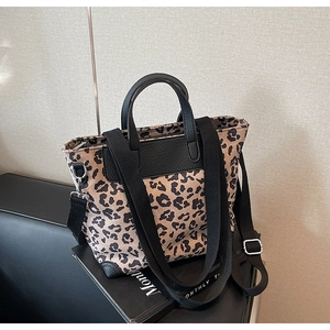 Leopard print tote bag detail showing leather trim and adjustable canvas shoulder strap