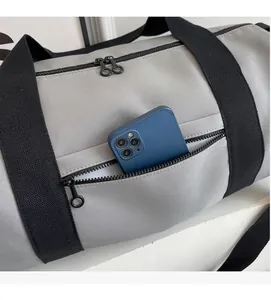 Detail view of the side pocket on the grey sports bag with a smartphone inside