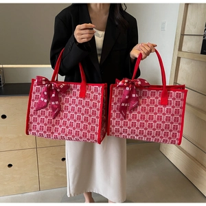 Detail of red wedding tote bag featuring traditional Xi characters and satin bow ribbons