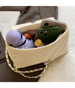 Spacious interior of beige quilted crossbody bag with daily items and chain strap