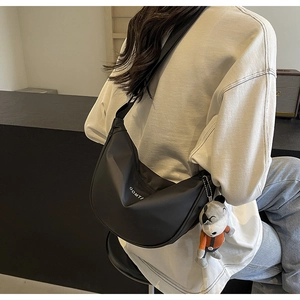 Sac hobo noir avec lettrage blanc et un pendentif mignon en peluche de loup gris