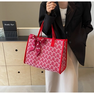 Detail view of red bridal tote bag with traditional Xi jacquard and silk scarf handle